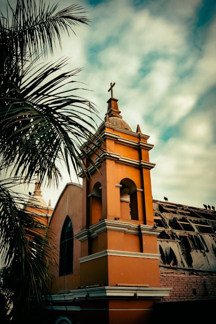 Vintage shot of a Catholic church tower with palm tree in Barranco, Lima, Perú.