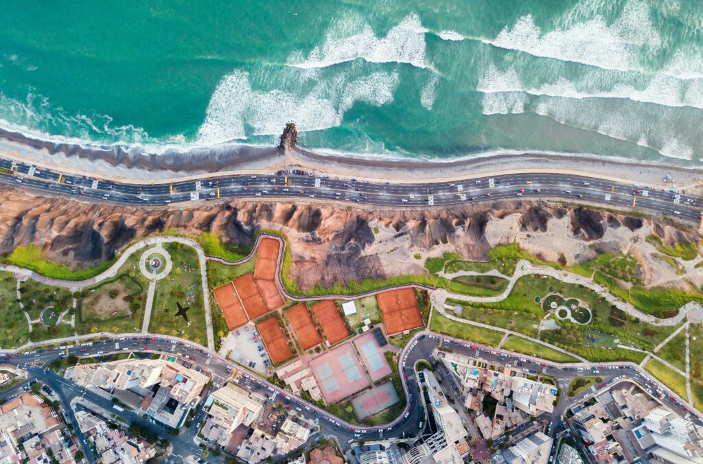 Stunning aerial shot of Miraflores coastline with ocean waves and urban landscape in Lima, Peru.