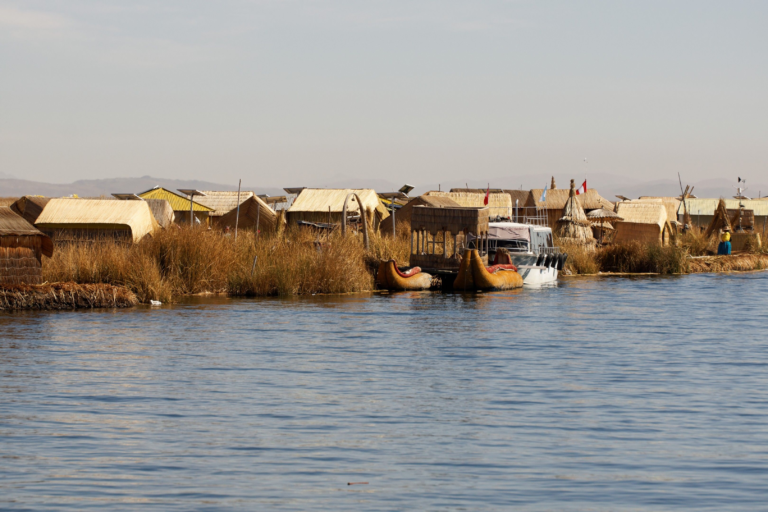 Explore the unique Uros floating village with traditional reed houses on Lake Titicaca, Puno, Peru.