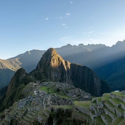 Dramatic aerial view of Machu Picchu with sunrays, capturing its ancient beauty and mountainous landscape.