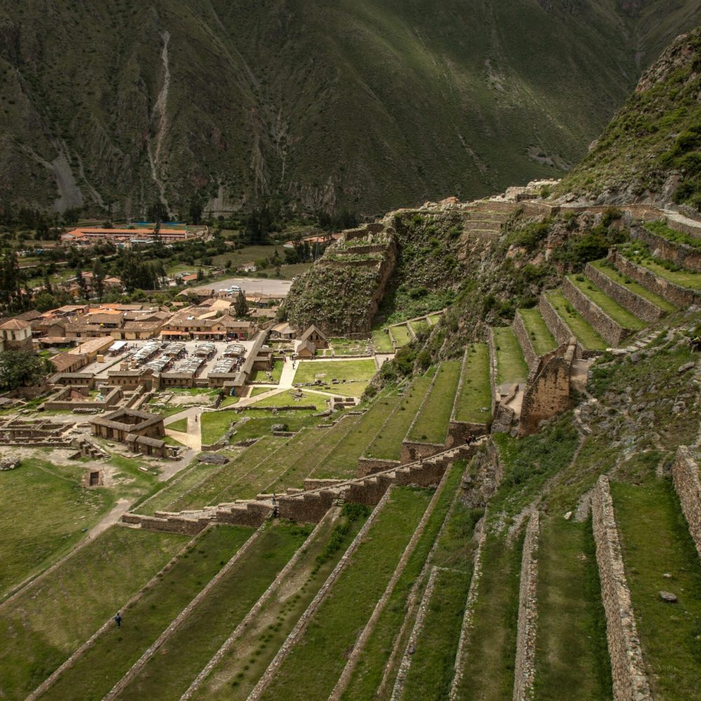 Explore the ancient Incan terraces of Ollantaytambo in Peru, captured in a stunning aerial view.